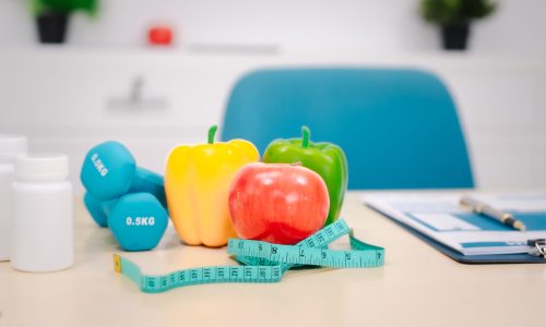 A nutritionist's table with a vegetable basket, fruits, pill bottles,dumbbell, symbolizing health