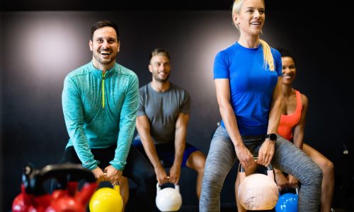 Fit happy people working out in fitness class at the gym